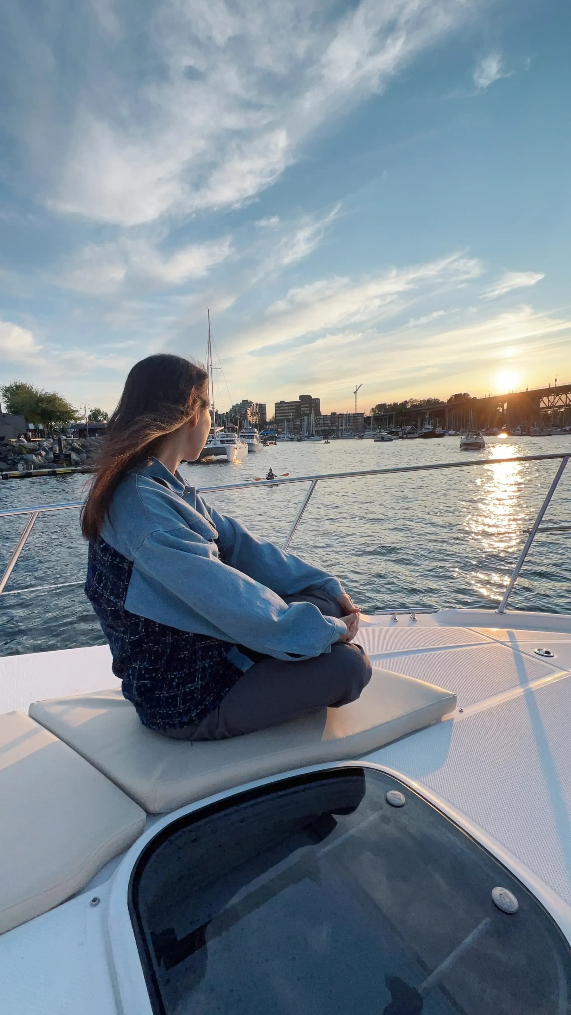 Guest watching the sunset from the bow of an Ocean Wave yacht in False Creek